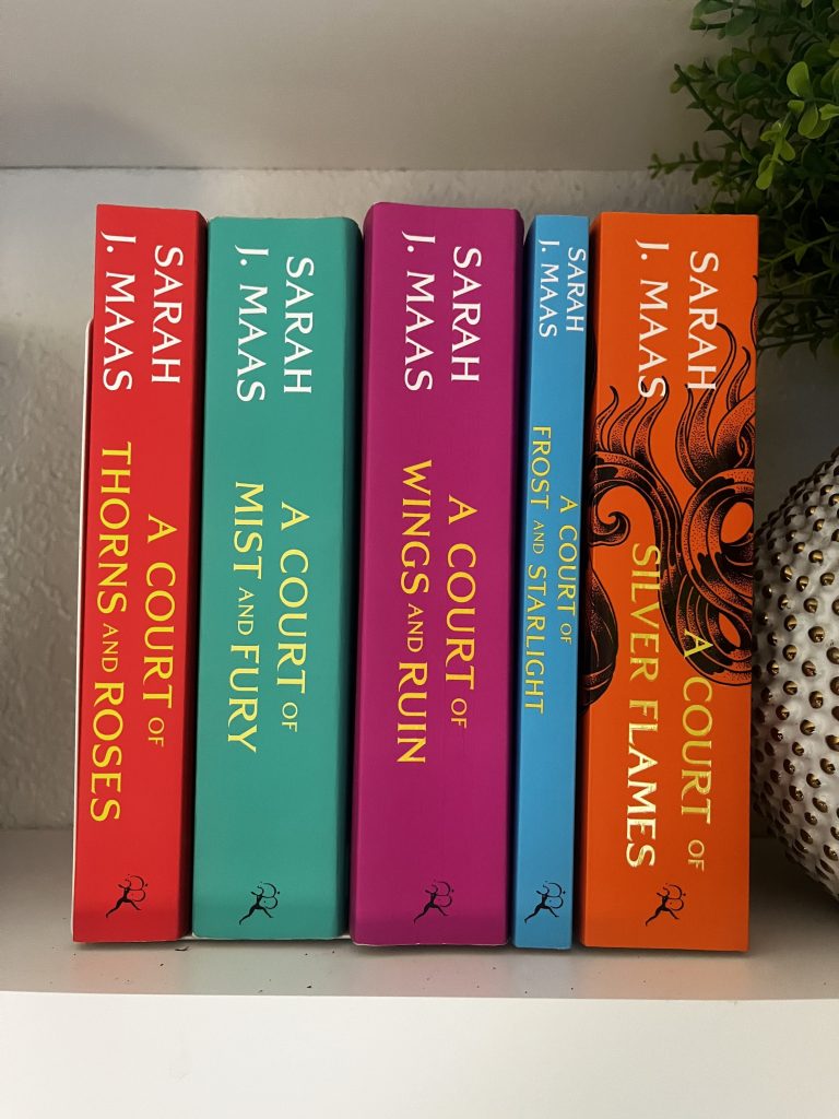 A Court of Thorns and Roses Series by Sarah J. Maas sitting on a bookshelf next to greenery.